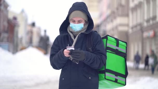 Delivery man με πράσινη τσάντα περιμένει την παραγγελία για την παράδοση — Αρχείο Βίντεο
