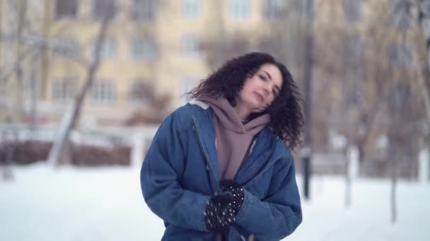 Lykkelig ung kvinde med afro krøller i en vinterby – Stock-video