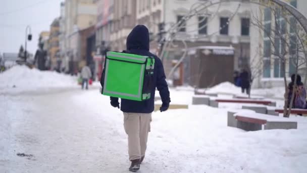Kurye kışın sırt çantasıyla yiyecek getiriyor. — Stok video