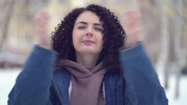 Gelukkig jong vrouw met afro krullen in een winter stad — Stockvideo