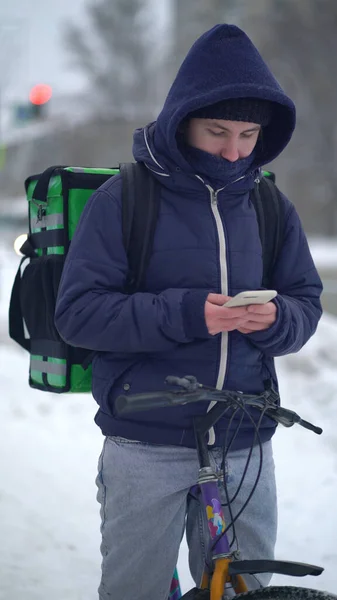 Levering man met groene bagage in afwachting van de bestelling voor levering — Stockfoto