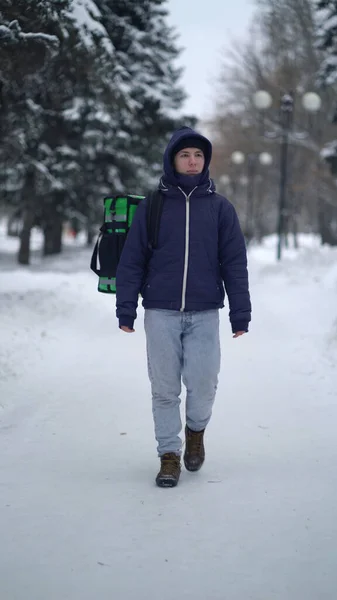 Kurye kışın sırt çantasıyla yiyecek getiriyor. — Stok fotoğraf