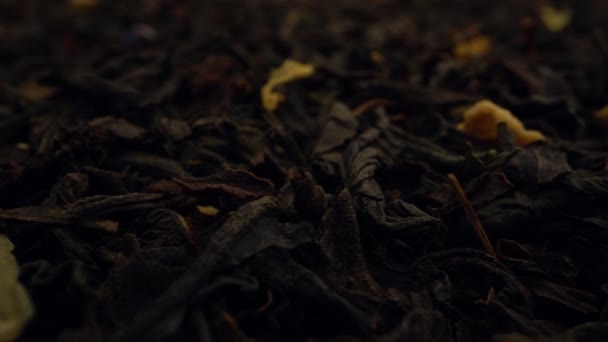 Extremely close-up dried black tea leaves background. — Vídeos de Stock