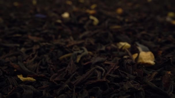 Extremely close-up dried black tea leaves background. — Stockvideo
