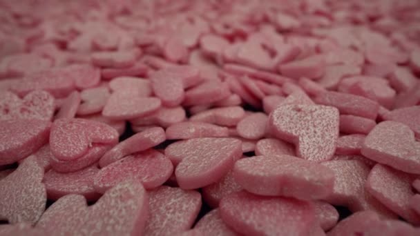 Roze macro snoepgoed besprenkelende hart-vormige achtergrond. — Stockvideo