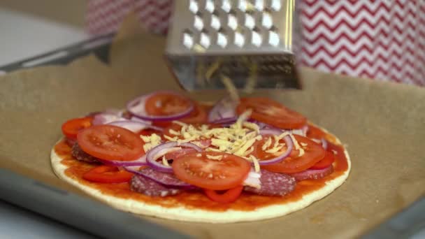 Vrouw chef zet geraspte kaas op pizza — Stockvideo