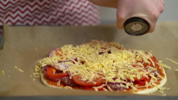 A lány elkészíti a pizzát és megszórja fűszerrel. — Stock videók