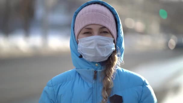 Femme en masque médical dans la rue de la ville en hiver — Video