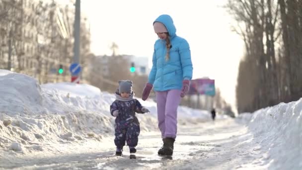 Moeder en dochter wandelen hand in hand in de winter — Stockvideo