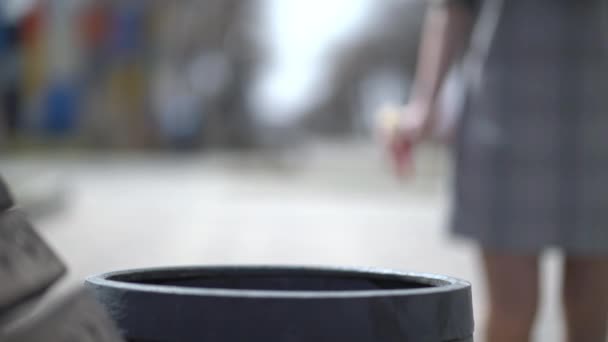 Woman throwing doner or shawarma into trash bin on the street — Stock Video