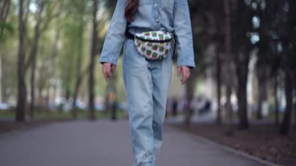 Fashionabla flicka reser genom park gator på en skateboard — Stockvideo