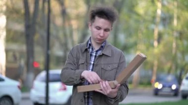 Pizza yiyen bir adam şehirde dolaşıyor.
