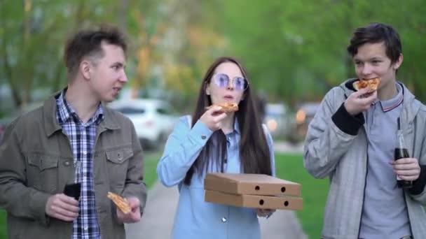 Ludzie jedzą pizzę i chodzą po mieście. — Wideo stockowe