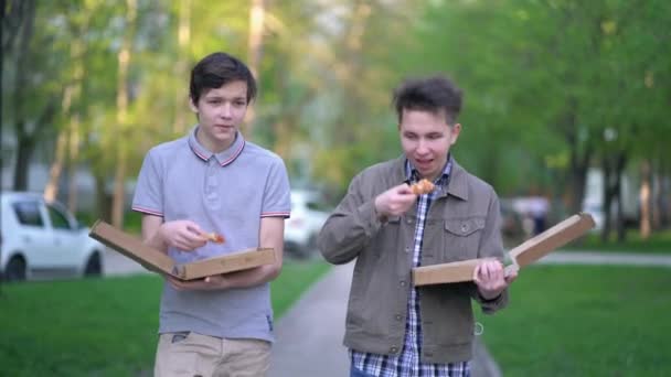 2人の友人が屋外でピザを食べている。ストリートフードのコンセプト — ストック動画