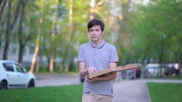 Man die pizza eet rondlopend in de stad — Stockvideo