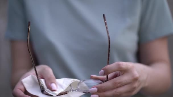 Женщина вытирает очки салфеткой — стоковое видео