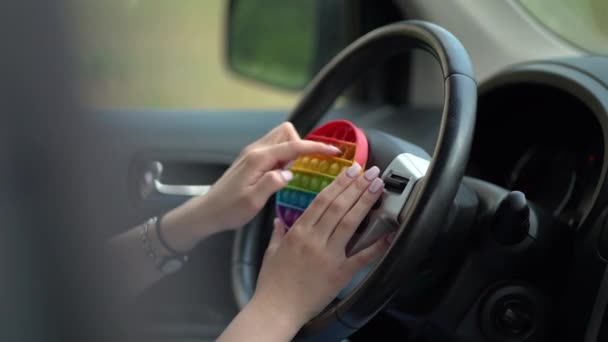 Woman using pop it or simple dimple in car — Stock Video