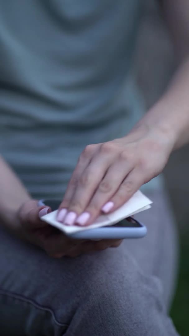 Femme essuyant téléphone portable avec une serviette — Video