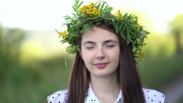 कैमरा को देखते हुए जंगली फूलों के मुकुट में एक महिला का चित्र — स्टॉक वीडियो