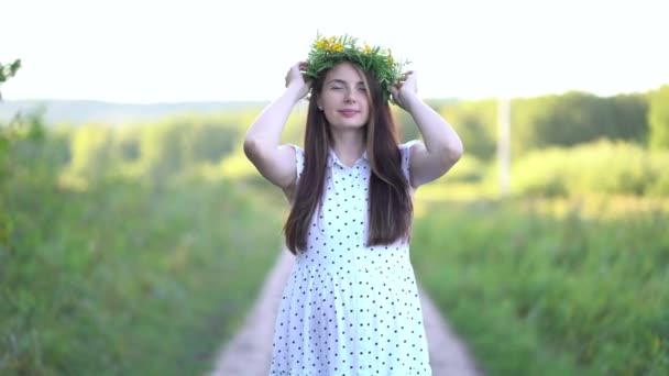 Pregnant woman with a wreath on her head walks outdoors — Stock Video