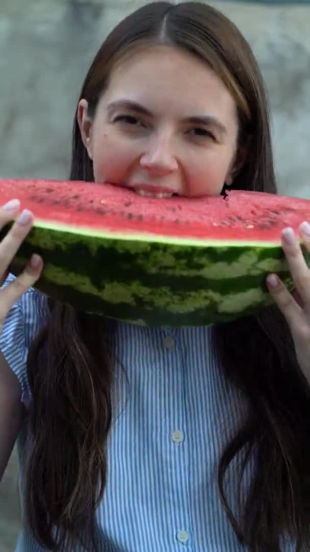 Egy gyönyörű fiatal nő enni görögdinnye portréja — Stock videók