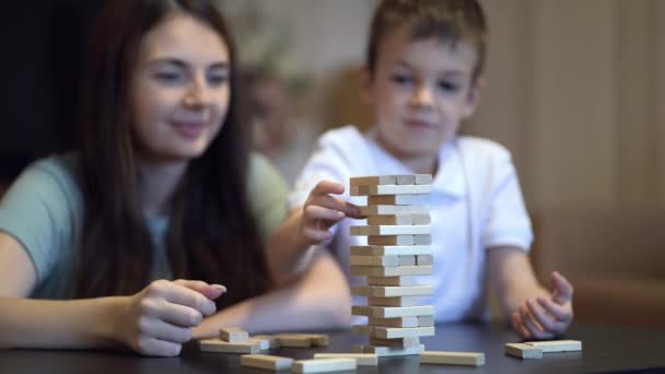 Mère et fils jouant dans le jeu de société avec tour en bois à la maison — Video