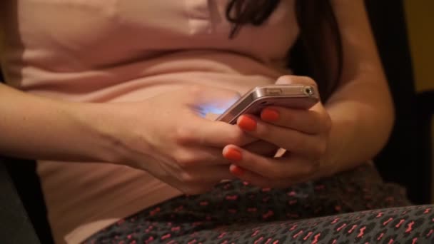 Mädchen sitzt und tippt SMS auf dem Handy — Stockvideo