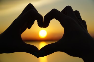 Kalp eller yönlendirir günbatımı kadın yapar
