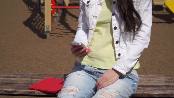 Une jeune fille utilise l'application sur votre smartphone — Video