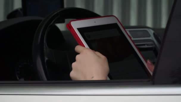 Junges Mädchen sitzt im Auto und benutzt App auf dem Computer-Tablet — Stockvideo