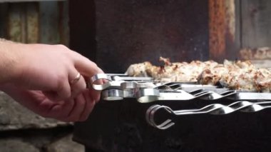 bir adam şişleri niteliğine pişirir