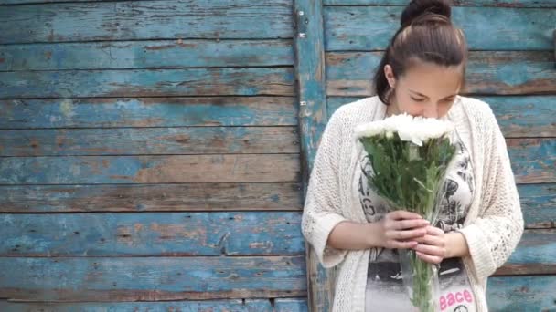 Mooi meisje ruiken een boeket van witte chrysanten — Stockvideo