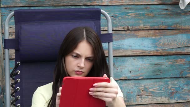 Красивая молодая девушка использует приложение в компьютерном планшете — стоковое видео