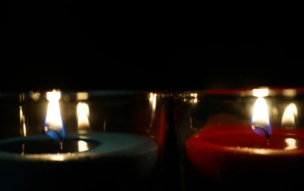 Brennende Kerze isoliert auf schwarz — Stockfoto