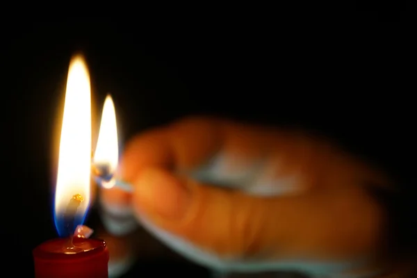 Mann zündet Kerze im dunklen Raum an — Stockfoto