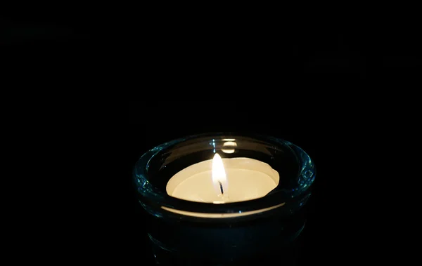 Brennende Kerze isoliert auf schwarz. — Stockfoto