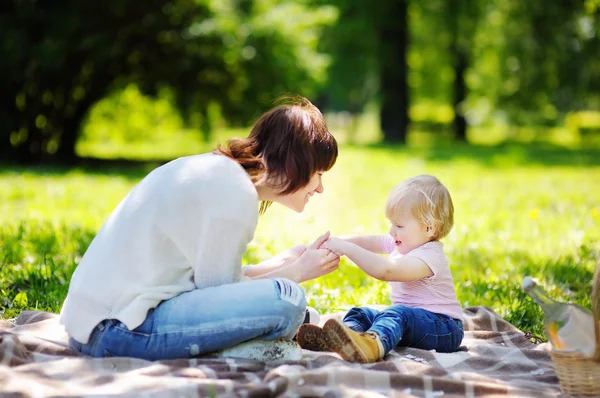 Giovane donna e il suo piccolo figlio nel parco soleggiato — Foto Stock