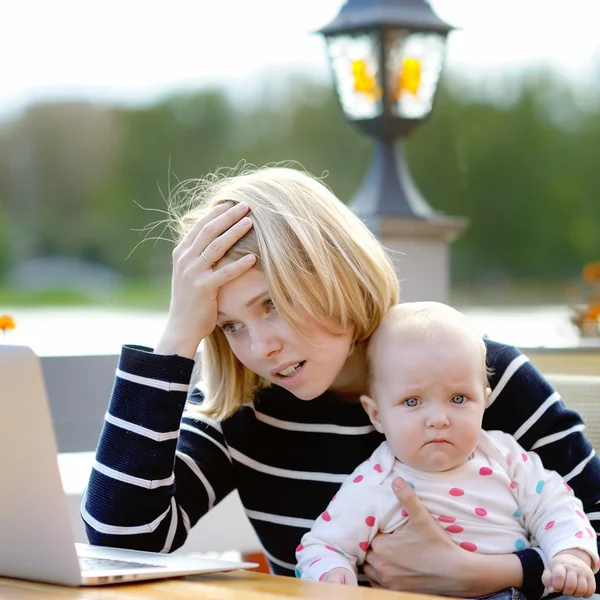 Stanco giovane madre lavorando oh suo computer portatile — Foto Stock
