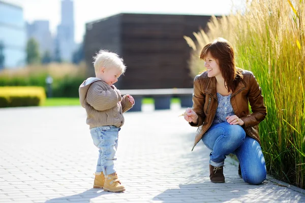 年轻女子和她蹒跚学步的儿子在外面玩 — 图库照片