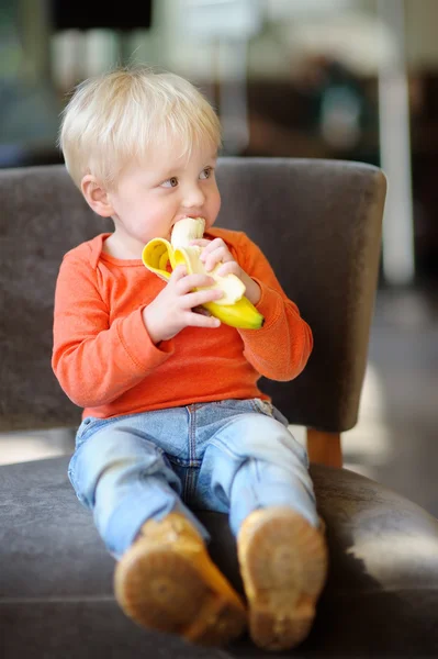 Toddler boy eating fresh banana — Stock Photo, Image