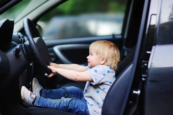 Petit garçon jouant dans la voiture des pères — Photo