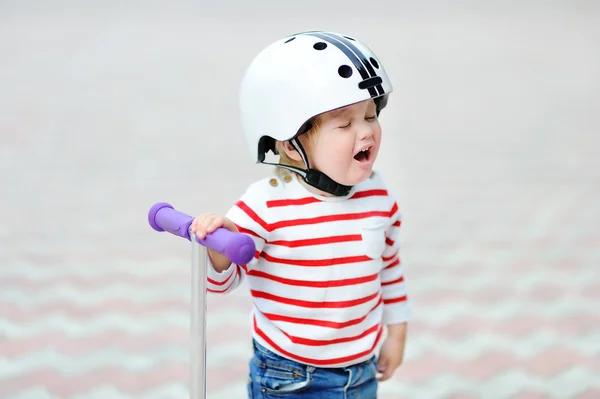 Criança chorando menino em capacete de segurança com scooter — Fotografia de Stock