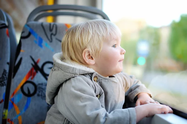 Хлопчик Тоддлер дивиться на поїзд або трамвайне вікно — стокове фото