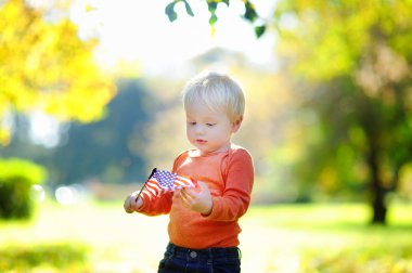 Amerikan bayrağı tutarak şirin yürümeye başlayan çocuk