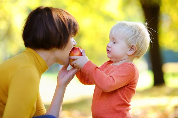 Vacker kvinna och hennes bedårande lilla barnbarn äta frukter — Stockfoto