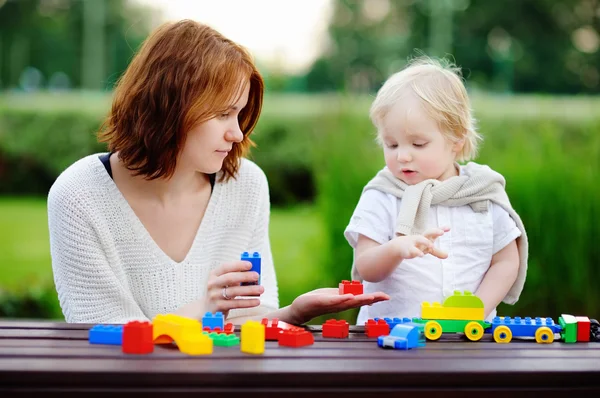 Jonge vrouw met zijn zoon spelen met kunststof blokken — Stockfoto