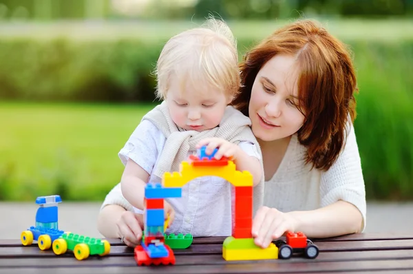 Молодая женщина с сыном играет с пластиковыми блоками — стоковое фото