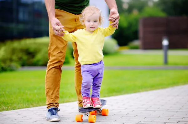 Kleuter meisje leren skateboard met haar vader — Stockfoto