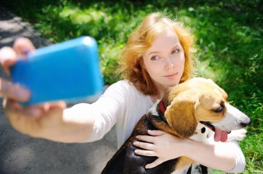 Genç hipster kadın selfie fotoğraf ile Beagle köpek yapma 