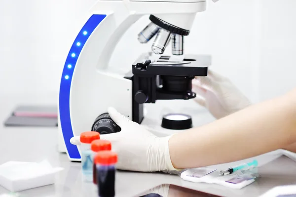 Close-up photo of scientist hands with microscope, examining samples and liquid — Stock Photo, Image